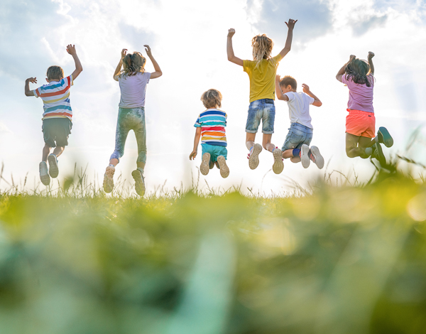 Trainer (m/w/d) für Kindersport & Bewegung in Karlsruhe Aufnahme von hinten sechs Kinder springen gleichzeitig in die Höhe